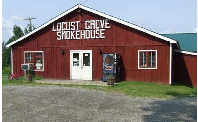 exterior of red barn with locust grove smokehouse in white letters