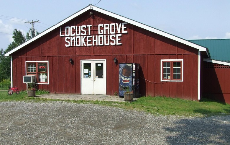 Exterior view of the red Locust Grove Smokehouse building.