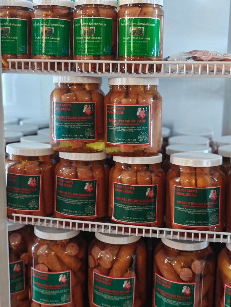 Jars of Locust Grove SmokeHouse Smoked Polish Sausage on refrigerator shelves.