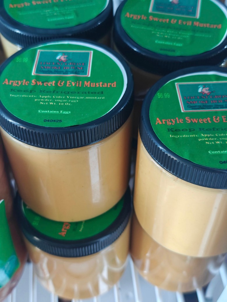 Jars of Locust Grove SmokeHouse Argyle Sweet & Evil Mustard on a shelf.