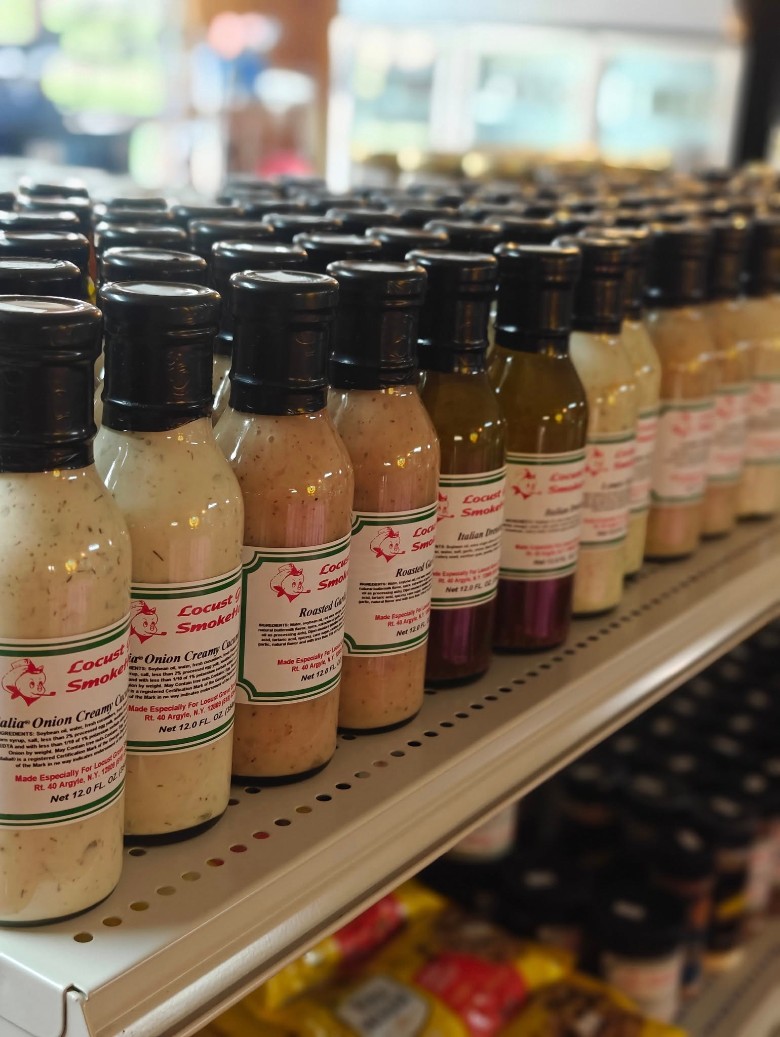 Rows of bottled dressings including Italian Onion Creamy and Roasted Garlic from Locust Grove SmokeHouse.