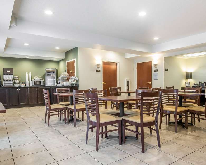 hotel breakfast area with buffet station, tables, and chairs