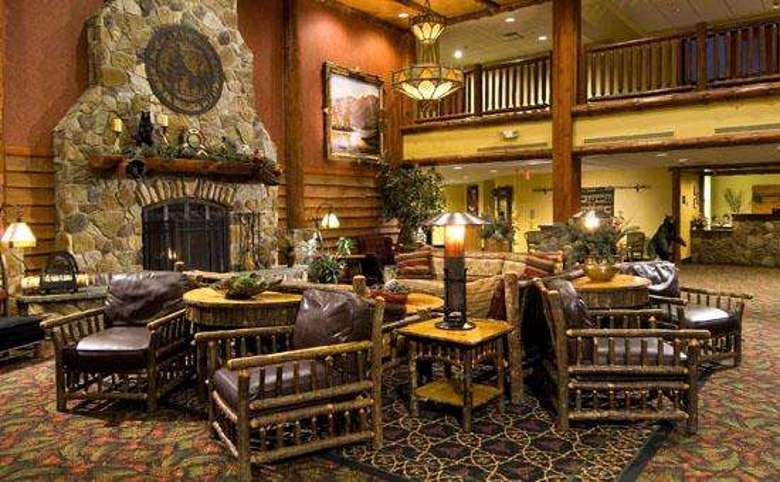 lobby of six flags great escape lodge with rustic furniture and a large stone fireplace