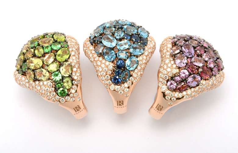 three rose gold rings with green, blue, and pink stones