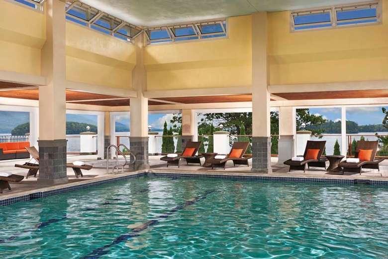 a large indoor pool with chairs along the edge.
