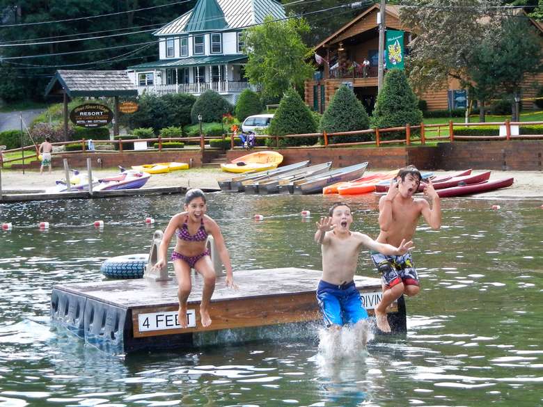three kids jumping off floating dock