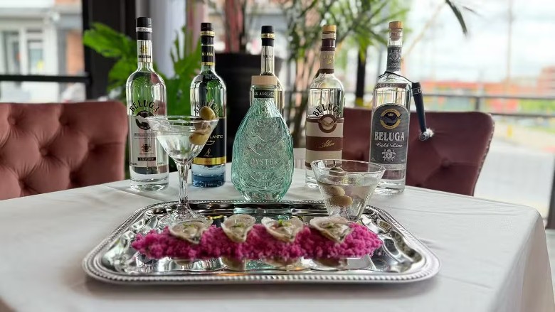 bottles of liquor lined up by a platter of oysters