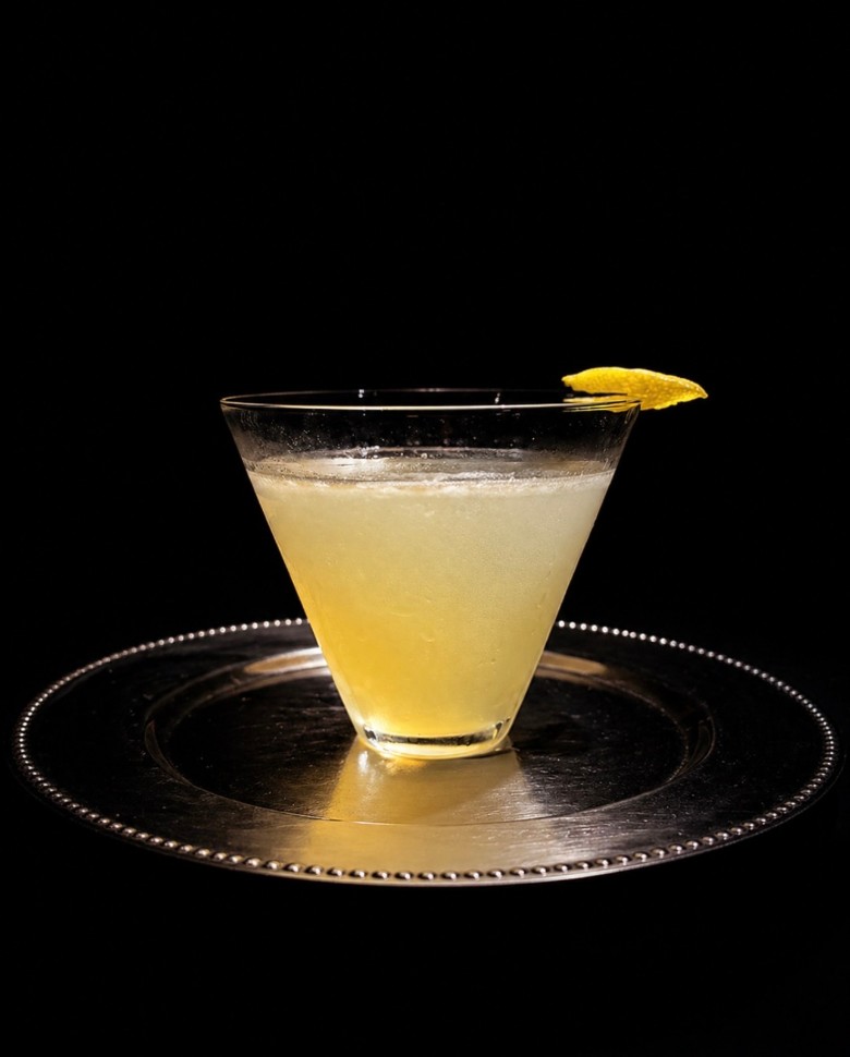 a yellow cocktail with a lemon garnish