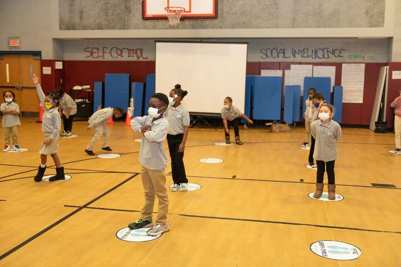 kids standing on white circles in a school gym