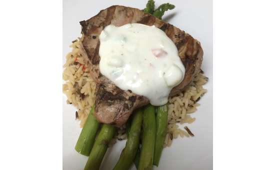 tuna steak with asparagus, rice, and a white sauce on top