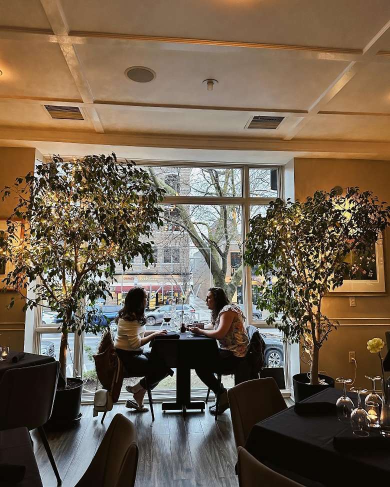 two women sitting in a window of a restaurant