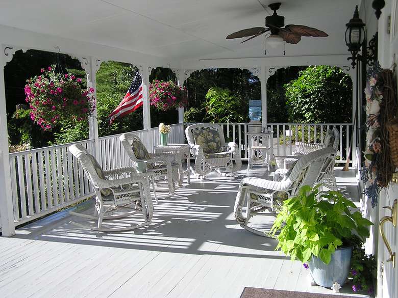 white chairs on a white deck with hanging plants