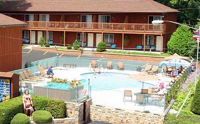 outdoor pool area surrounded by buildings at the mohican motel