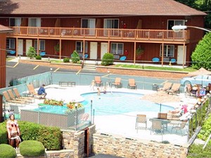 outdoor pool area surrounded by buildings at the mohican motel