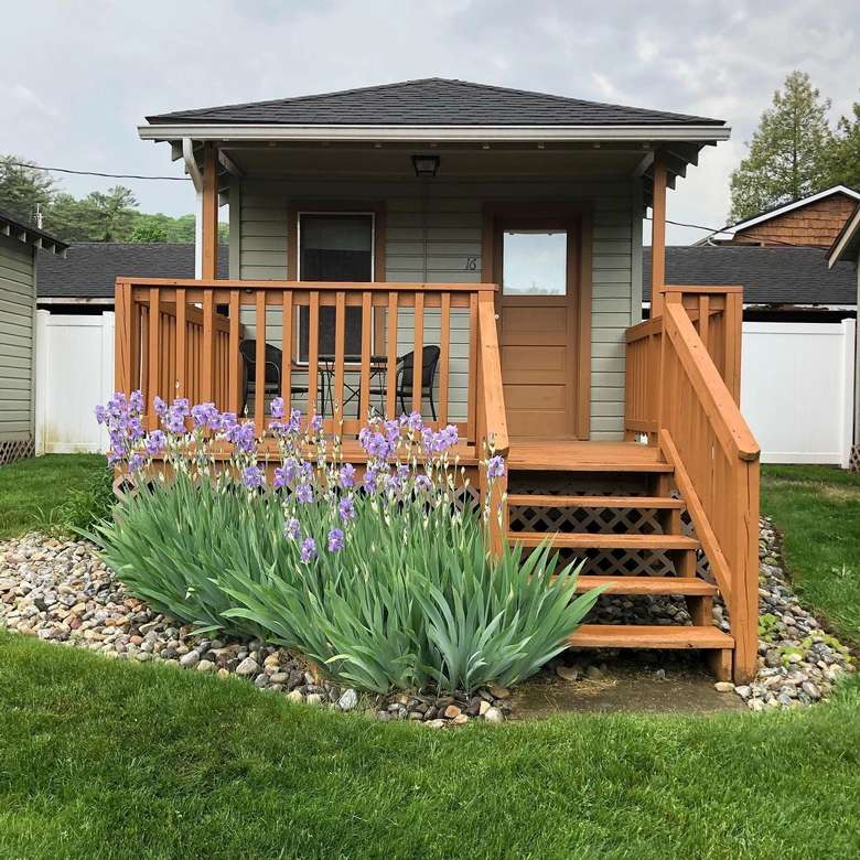 tiny house with porch and flowers in front