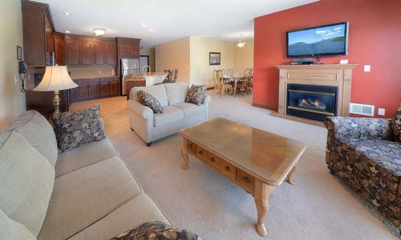 a living room area with flat screen TV, coffee table, couch