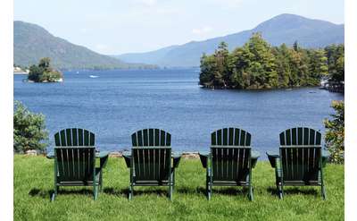 four green adirondack chairs overlooking lake george