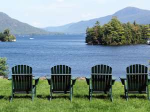 four green adirondack chairs overlooking lake george