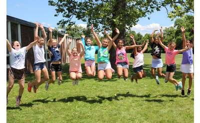group of kids jumping up outside