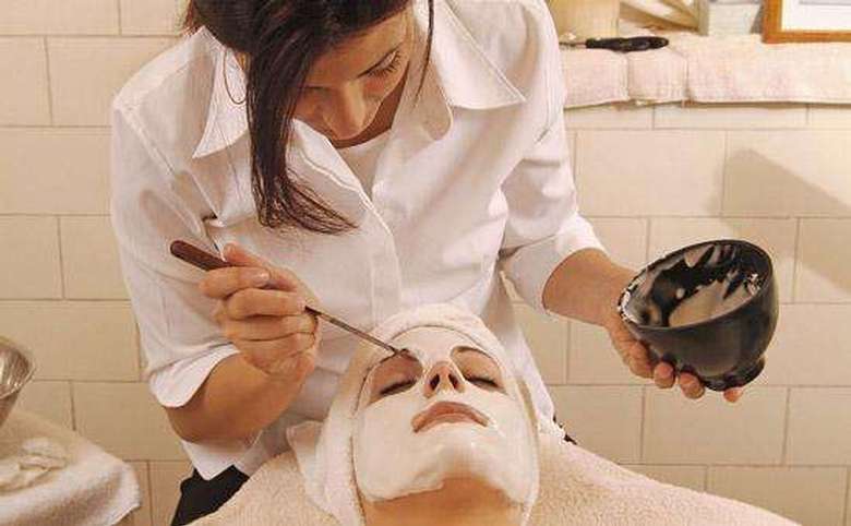esthetician applying a facial treatment to a client