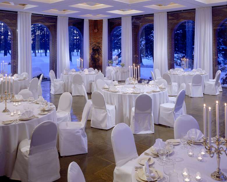 ballroom decorated for a wedding with white tablecloths and chair covers