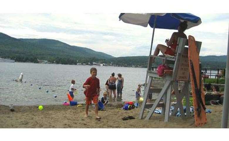 Kids playing in the sand near a lifeguard station on Lake George