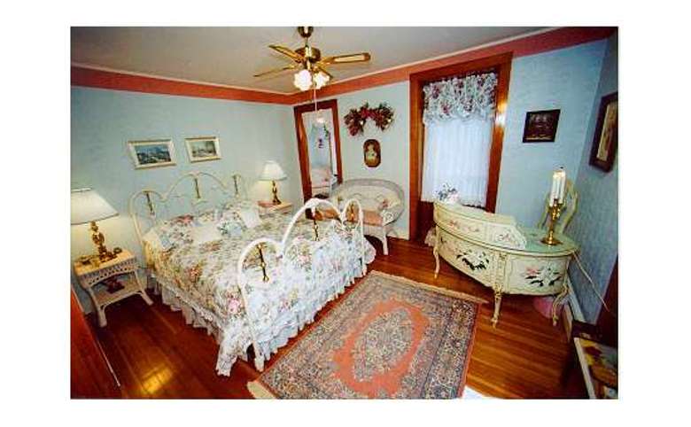 victorian bedroom with a queen-sized bed and blue wallpaper