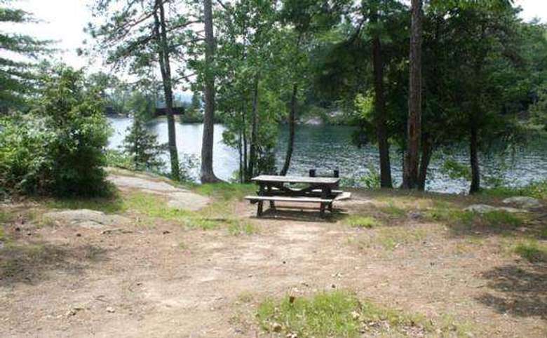 an island campsite with a picnic table and grill