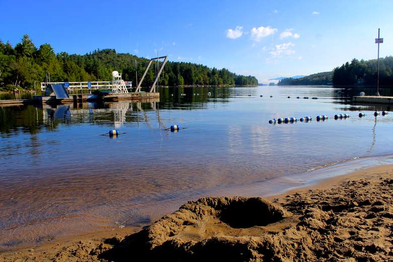 beach on long lake showing swimming area and large swim-to dock