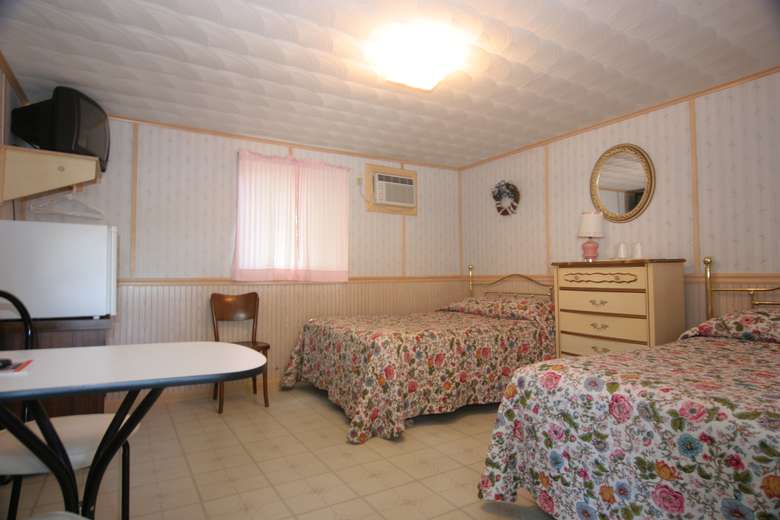 bedroom with two beds, floral blankets