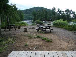 a campground area with a tent platform and two picnic tables