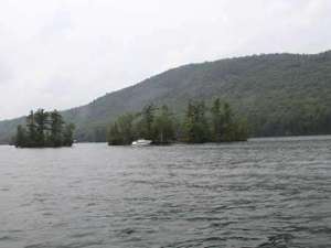 two islands on a lake with mountains in the background