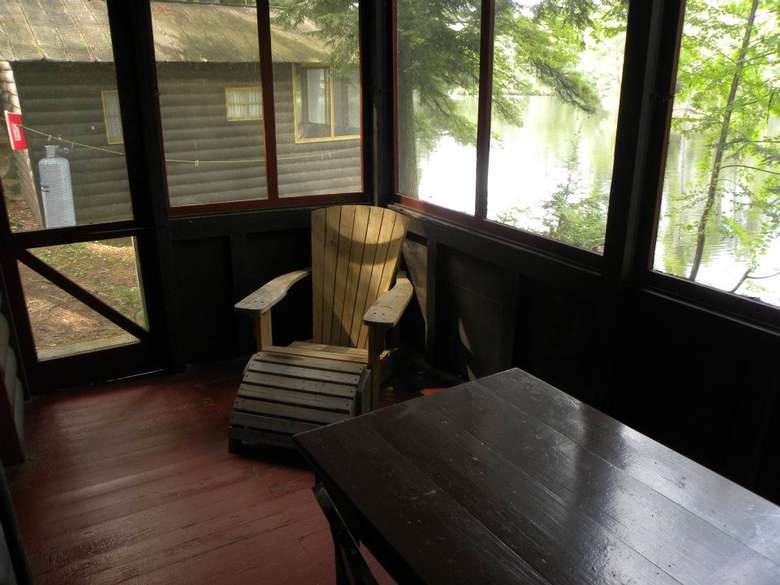 a screened-in porch with a chair and table