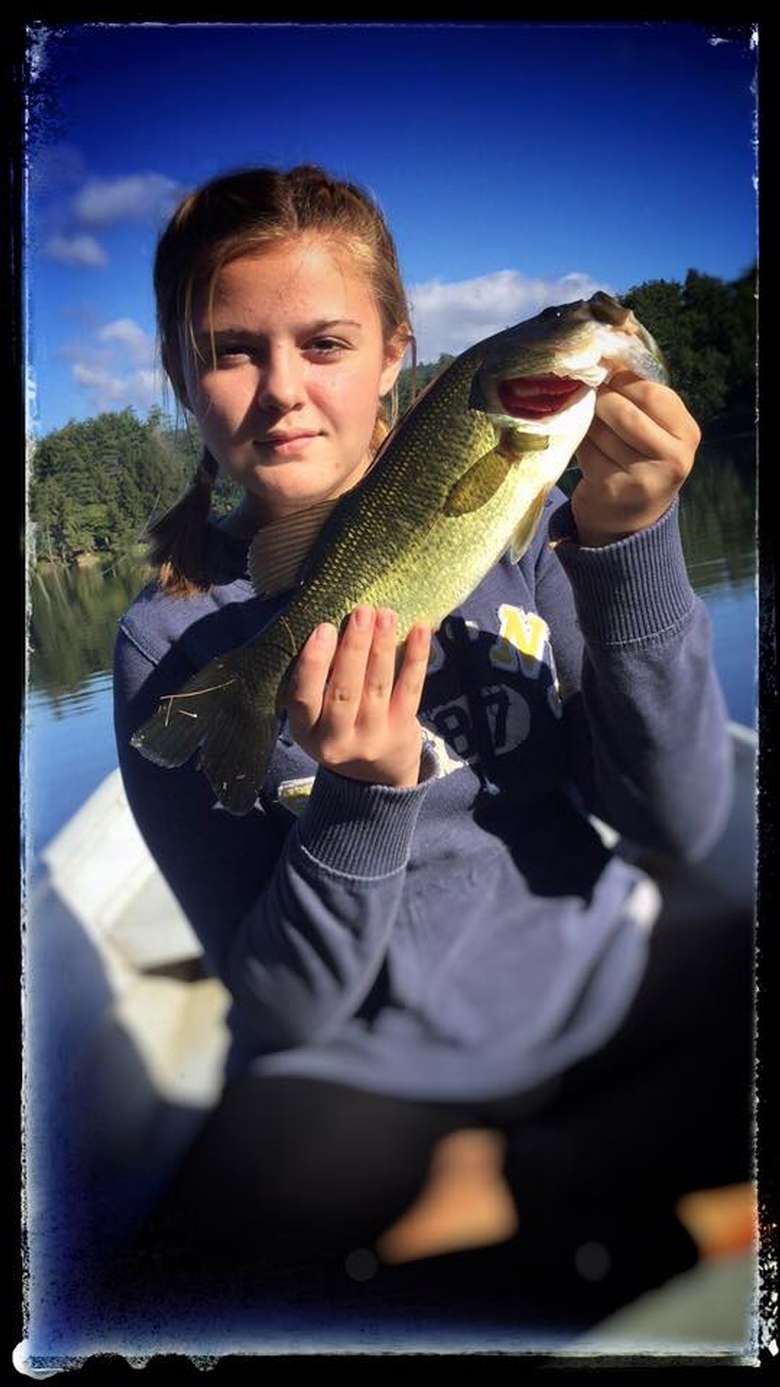 girl holding up a fish