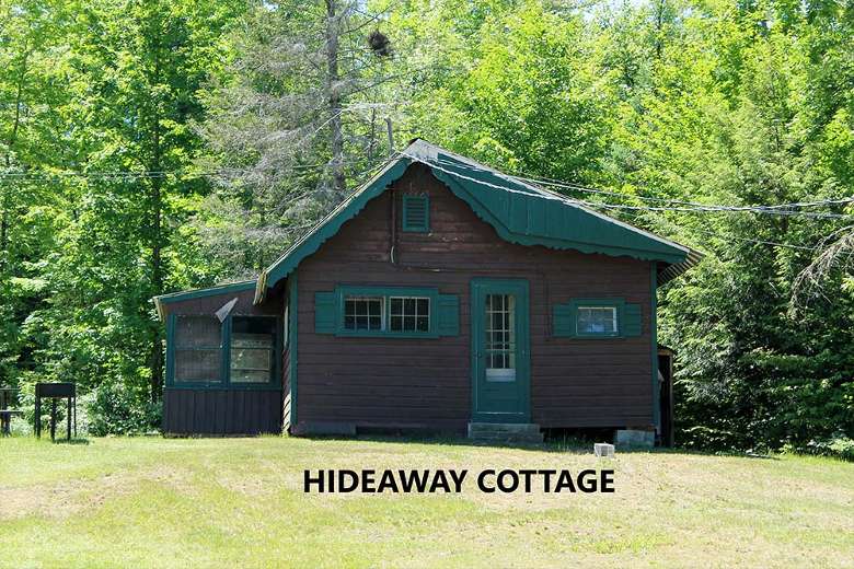 dark brown cabin with the words hideaway cottage on the picture