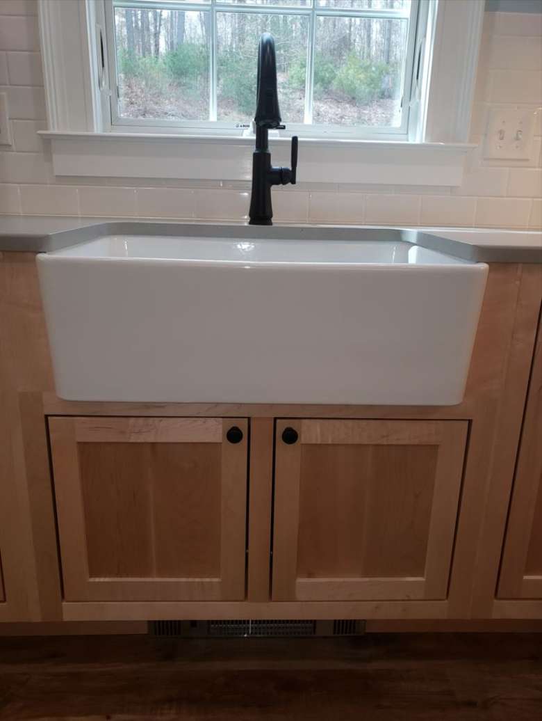 Custom made cast iron farmhouse sink cabinet in clear lacquer