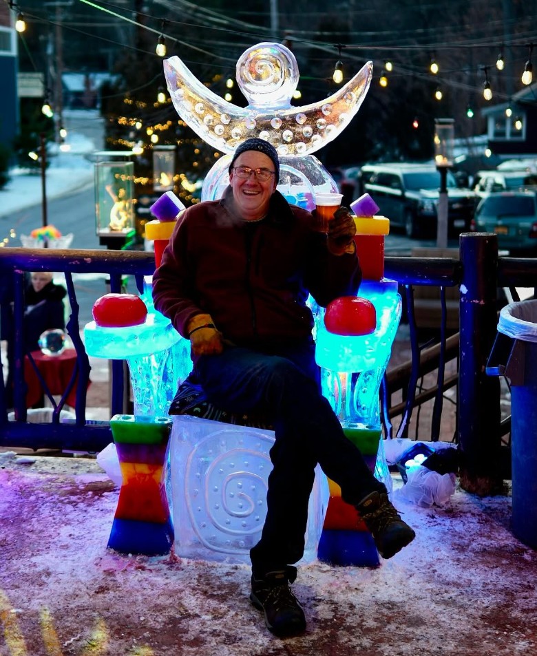 man seated on an ice chair at an ice bar event