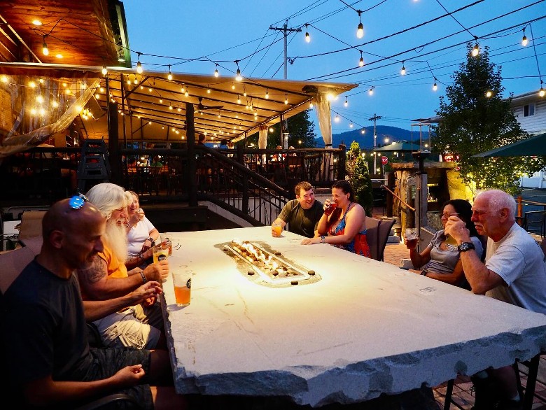 people outdoors at a patio table in the evening
