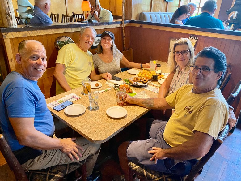 three men and two women at a restaurant table