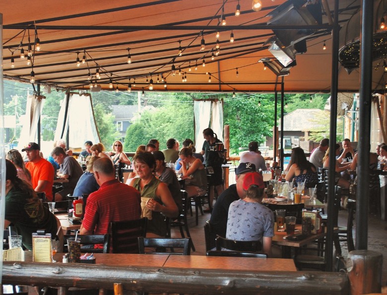 people seated outdoors under a covered patio