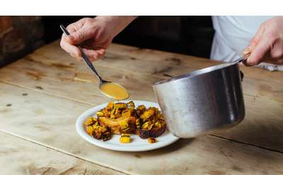 chef pouring sauce onto a dish