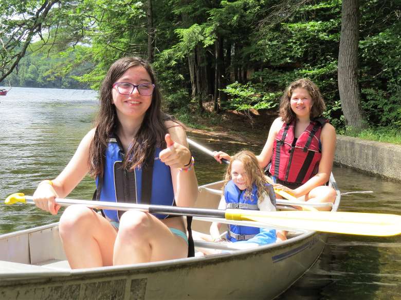 smiling group of campers in a canoe