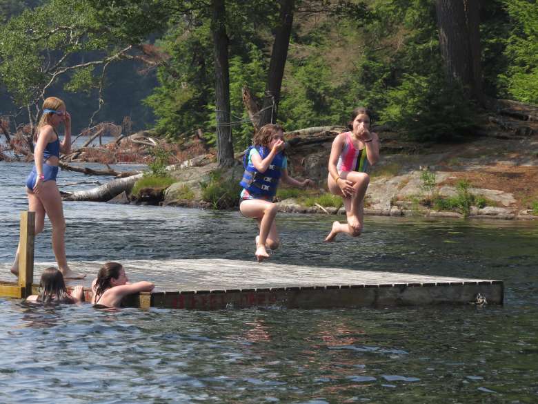 campers jumping into swim area