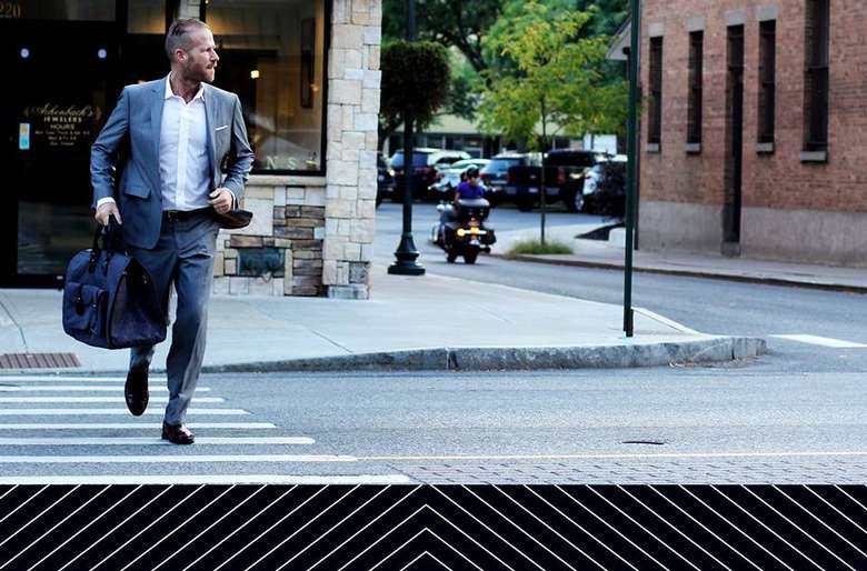 a sharply dressed man crossing the street