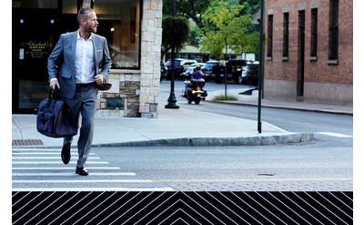 a sharply dressed man crossing the street