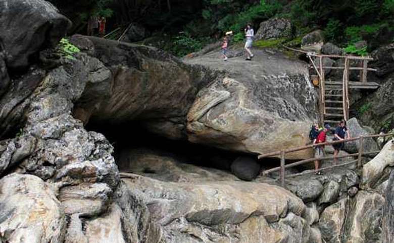 group of tourists explore the entrance of a cave