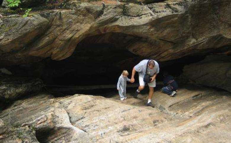 Parent waking with a child hand in hand out of a cave
