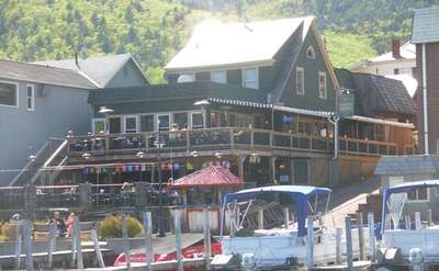 view of Christie's from the lake, showing boats, docks and outdoor decks for dining