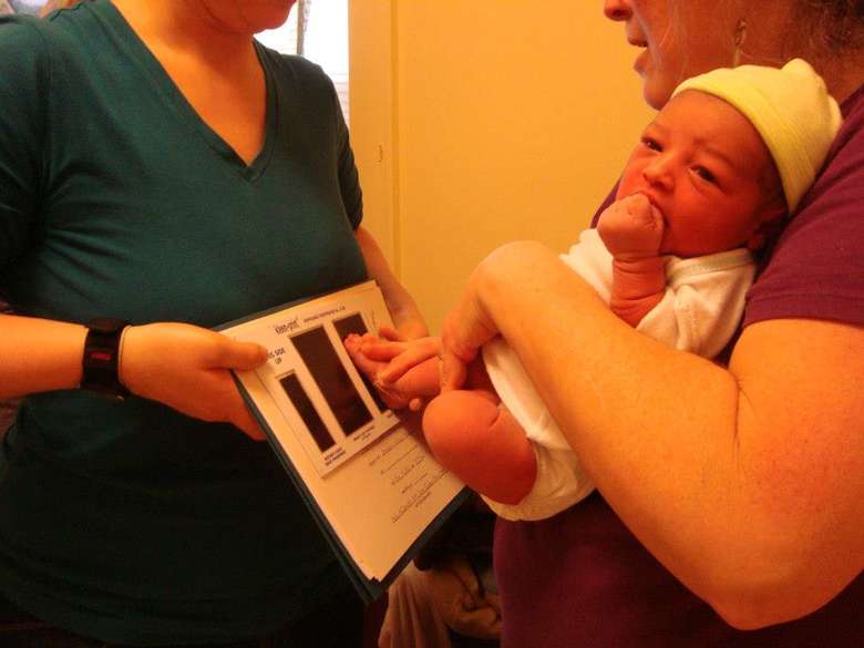 newborn baby getting his feet printed