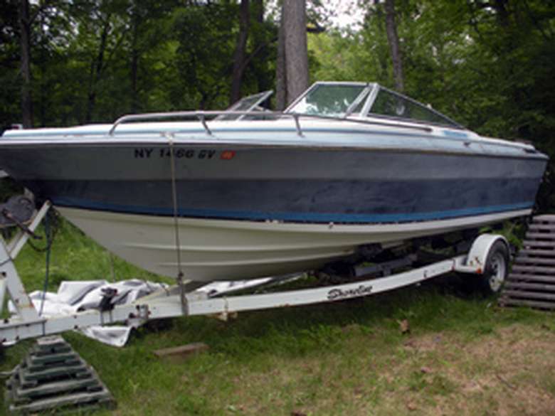 a large motorboat sitting on top of a trailer on a field
